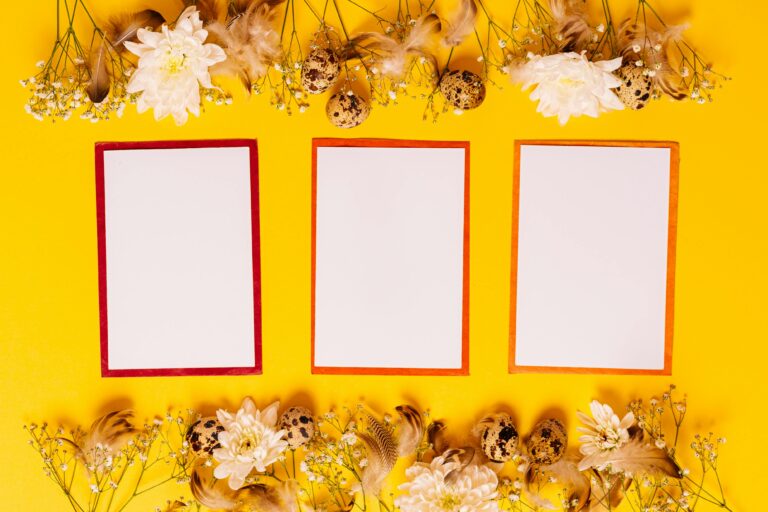 Vibrant flat lay featuring three cards surrounded by flowers on a yellow background.